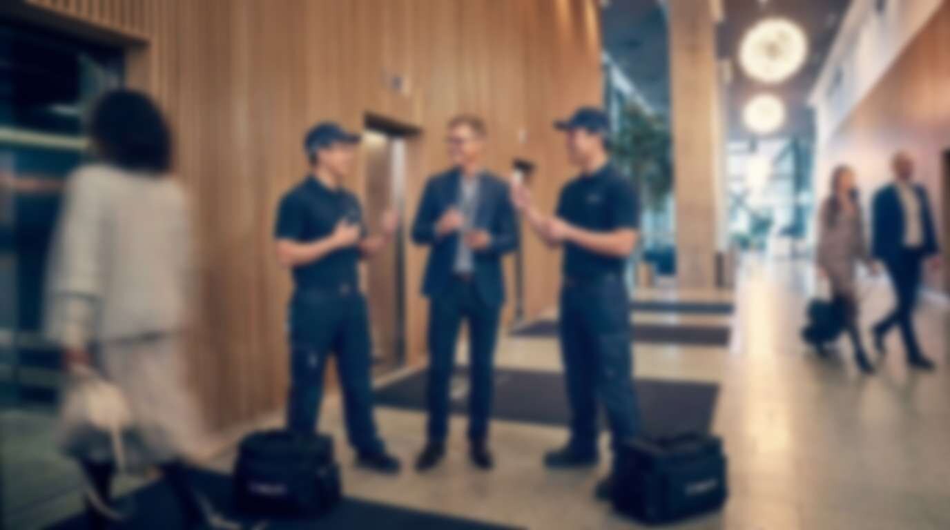 WELIFT technicians consulting a building owner in a lift lobby